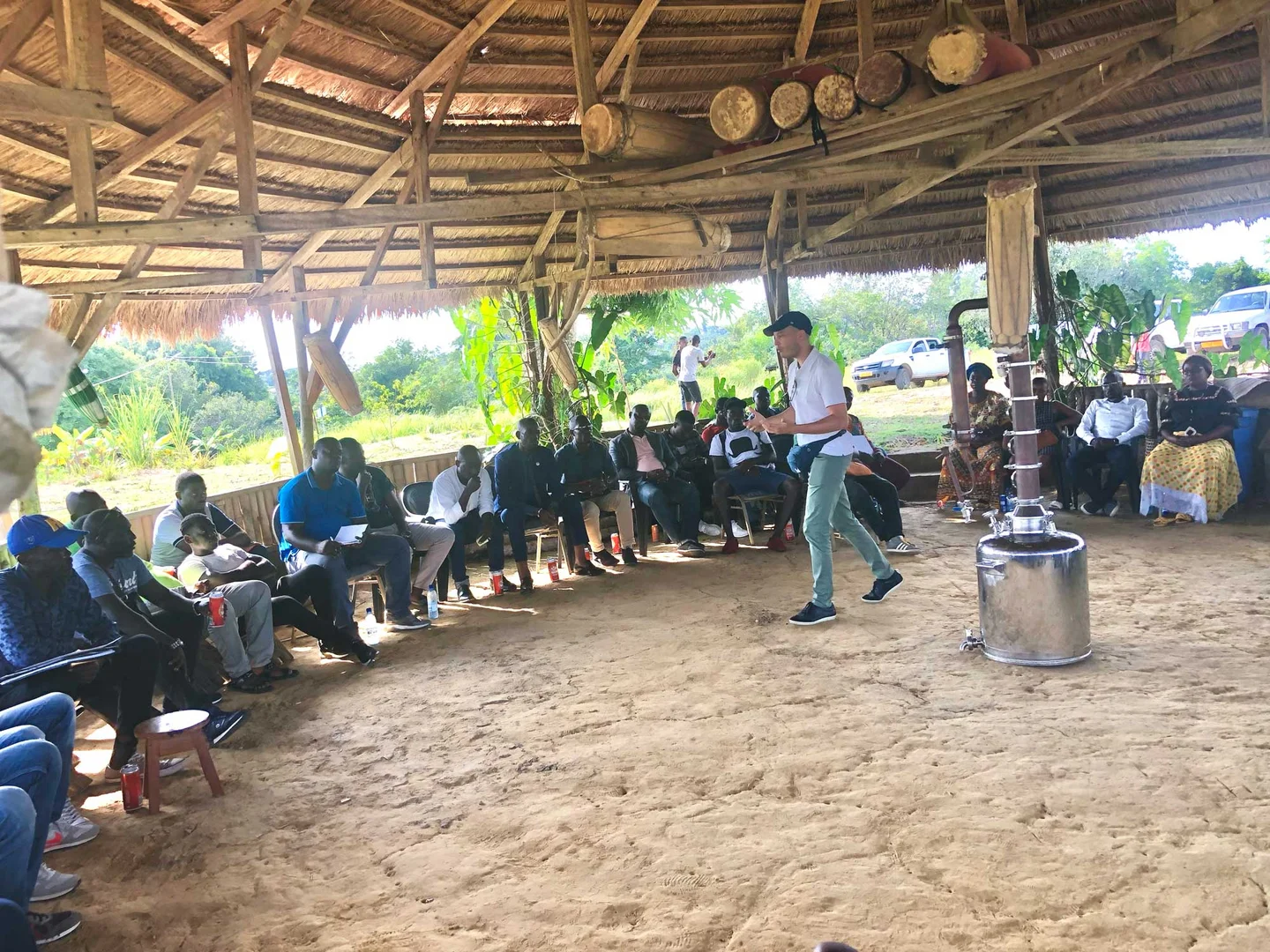Assemblée de participants sous une grande paillote de Ndossi Village