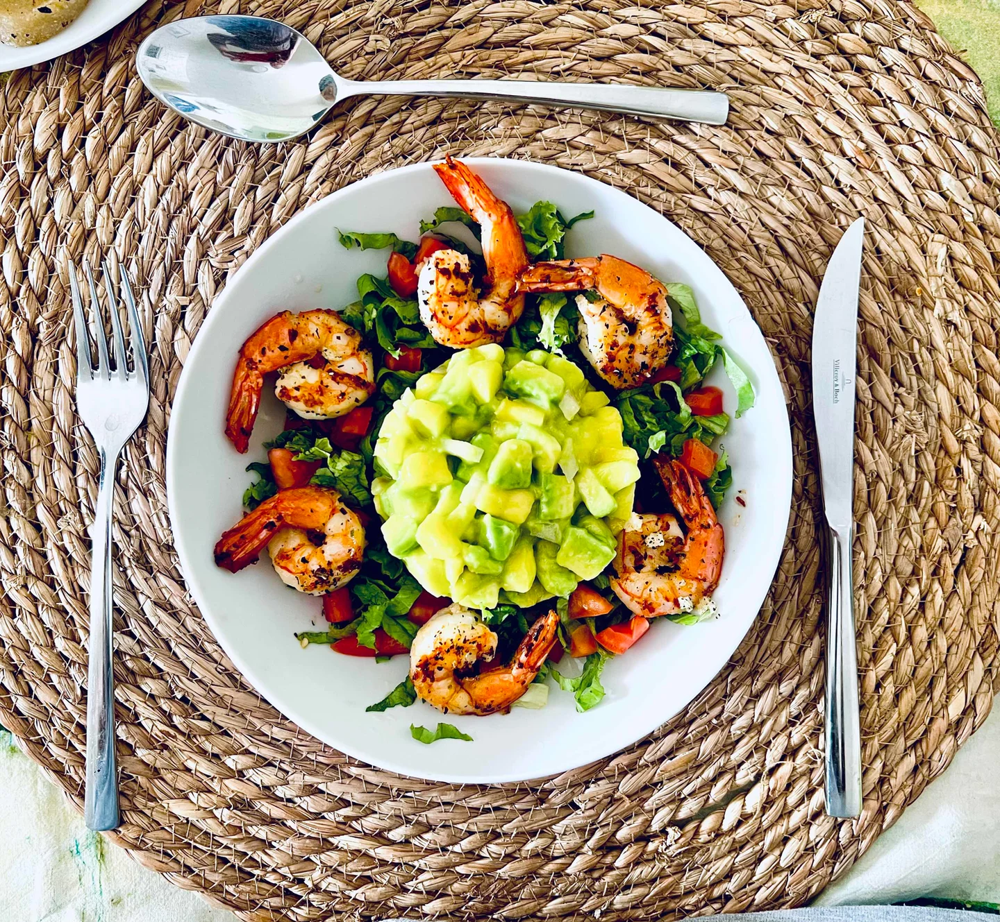 Assiette de poisson et de légumes présentée sur un set de table tressé