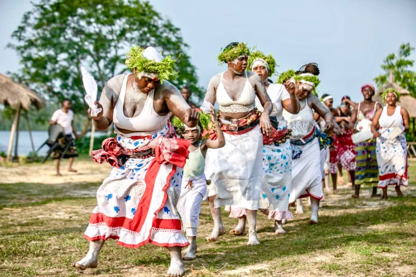 Danseurs en mouvement en tenues rouges et blanches à Ndossi Village