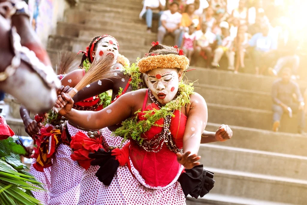 Danseuse gabonaise en tenue rouge et végétale lors d’une cérémonie