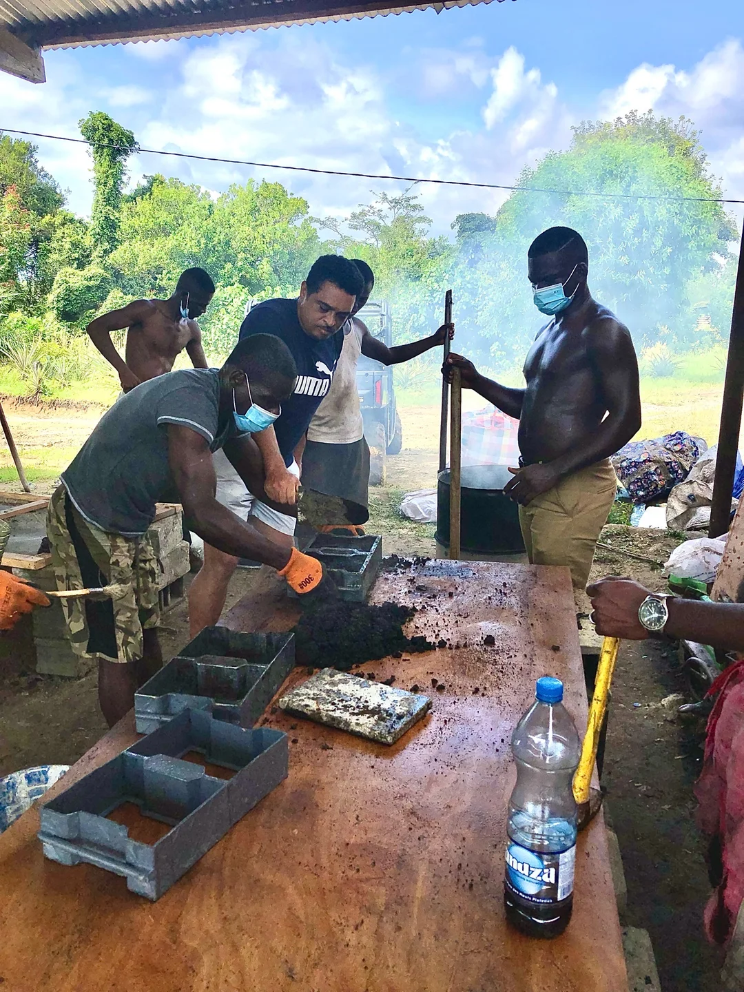 Démonstration pratique dans un atelier de recyclage sous une paillote