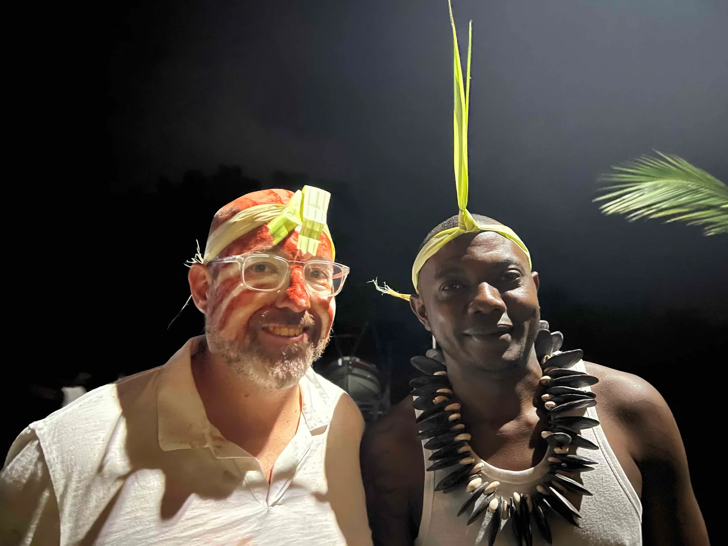 Deux participants avec coiffes et tenues traditionnelles au village Mikumu