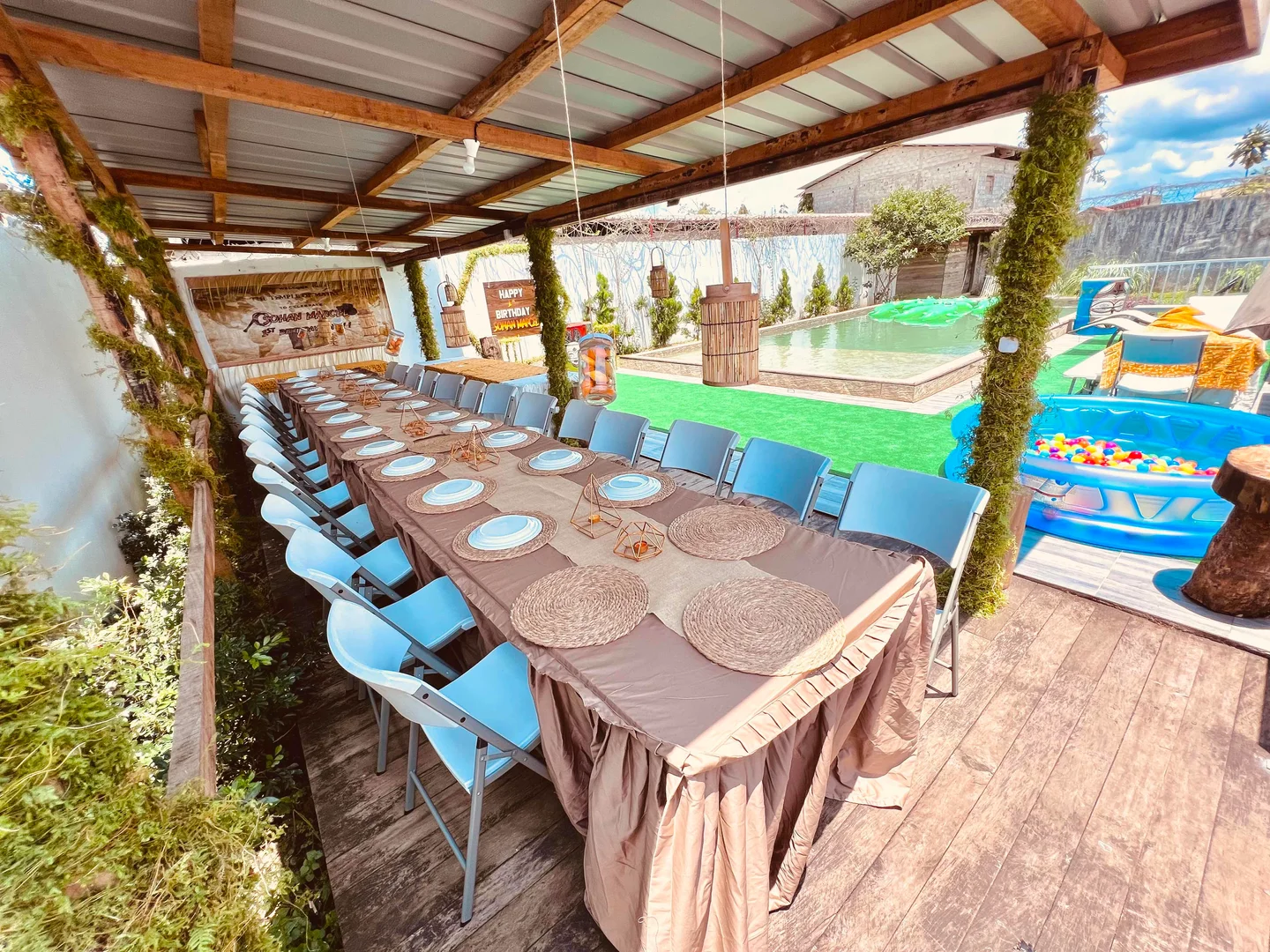 Grande table dressée sous une paillote ouverte sur la rivière