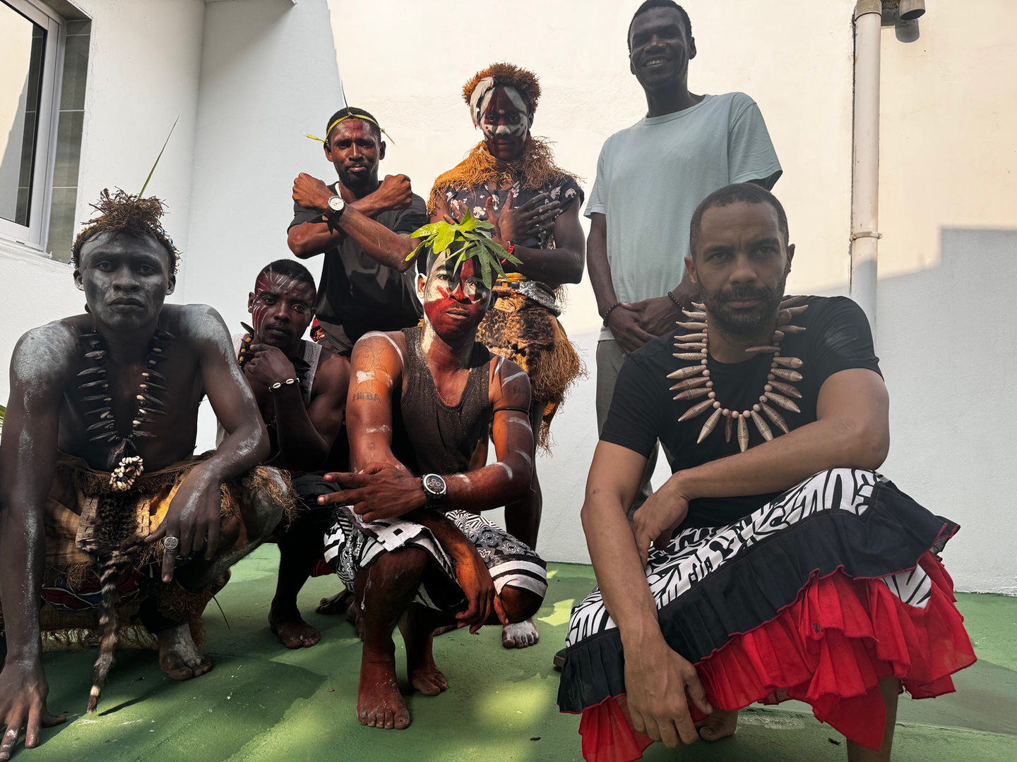 Groupe de participants en tenues traditionnelles devant un bâtiment
