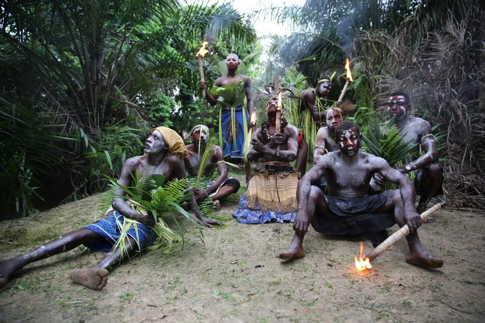 Groupe en tenues traditionnelles dans la forêt, au milieu des racines