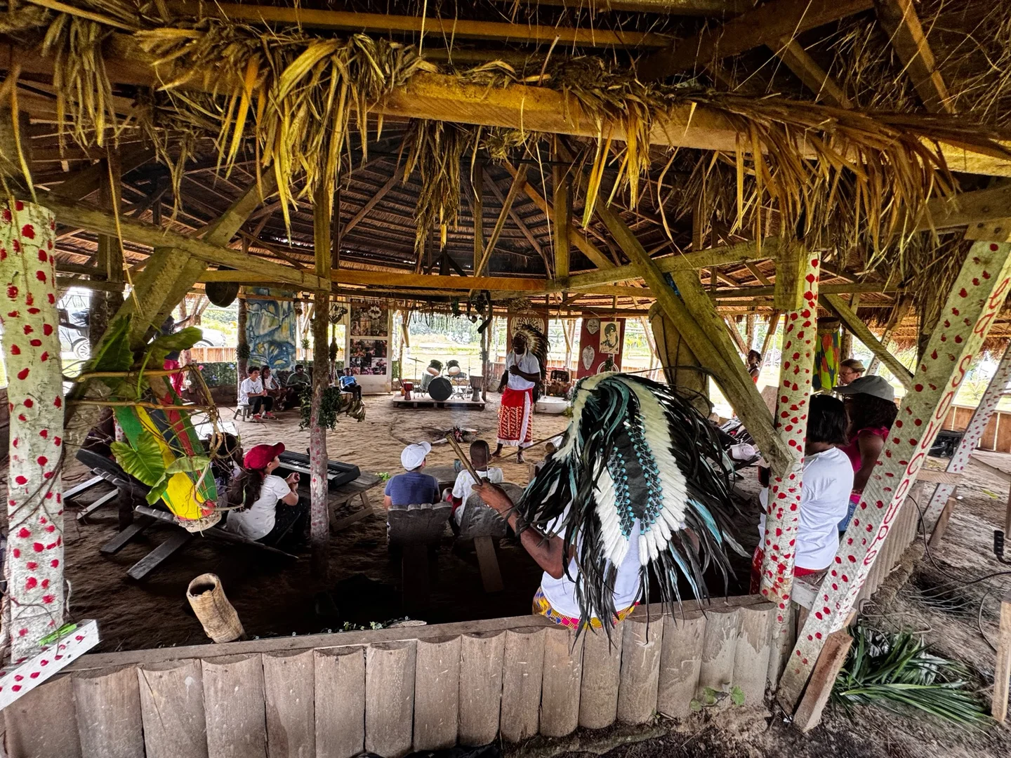 Participants assis sous une paillote au toit de chaume