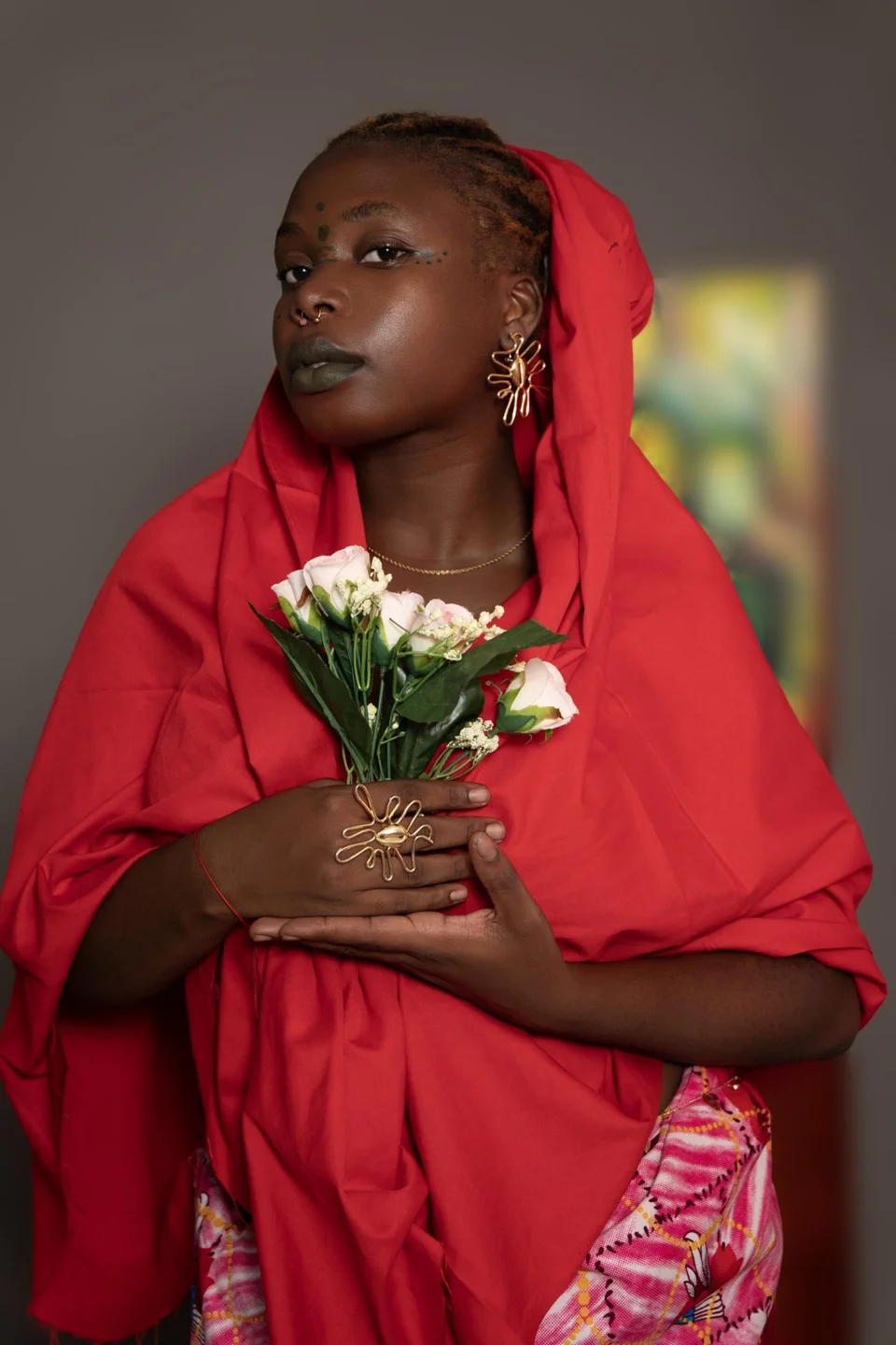 Portrait de Franck’Art en tenue rouge, avec un bijou végétal