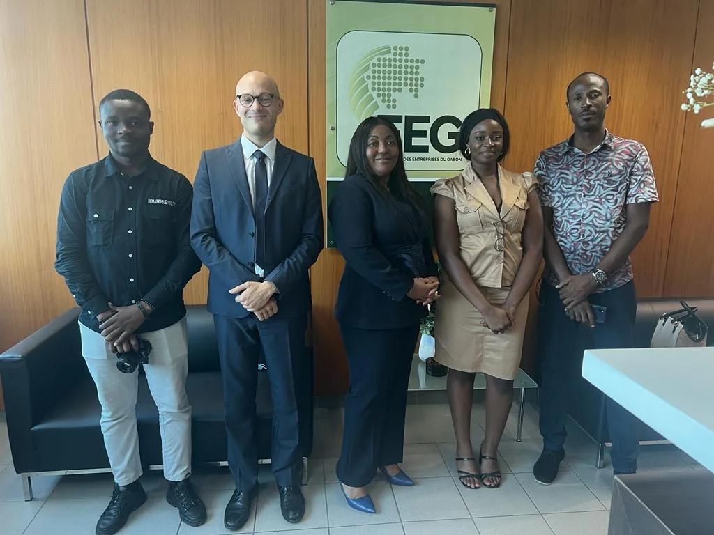 Rencontre de partenaires devant le logo de la Fédération des entreprises du Gabon