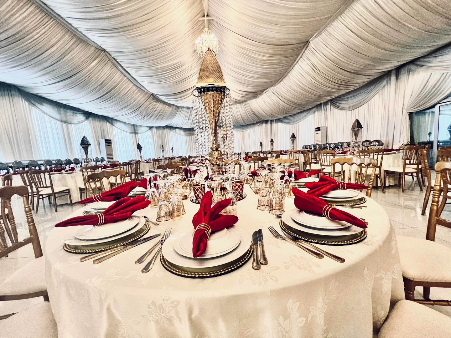 Tables dressées pour une réception sous une tenture blanche